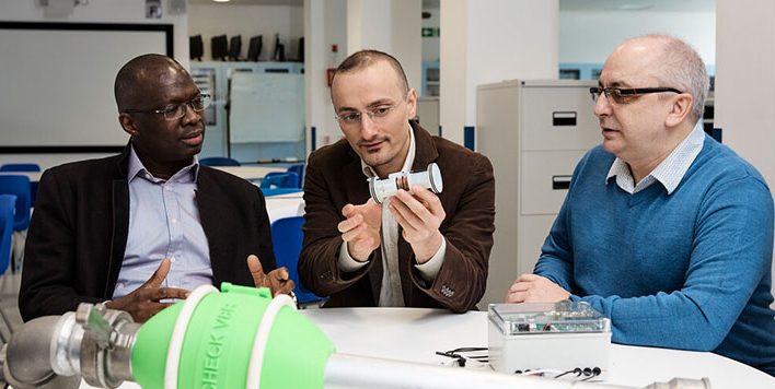 Group of three members of the KTP project team looking at one of the products in development.